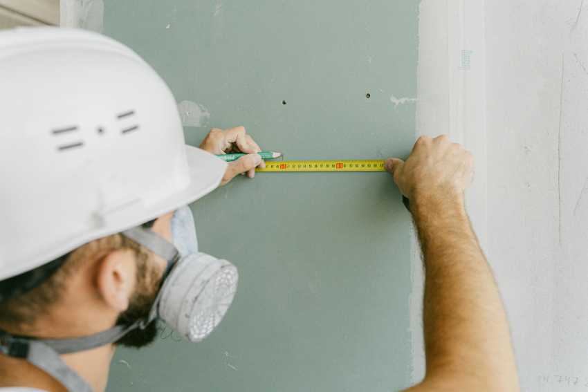 Workman measuring on a wall